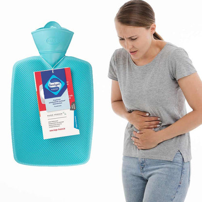 Türkisfarbene Wärmflasche neben Frau, Hand am Bauch, mit Halblamelle