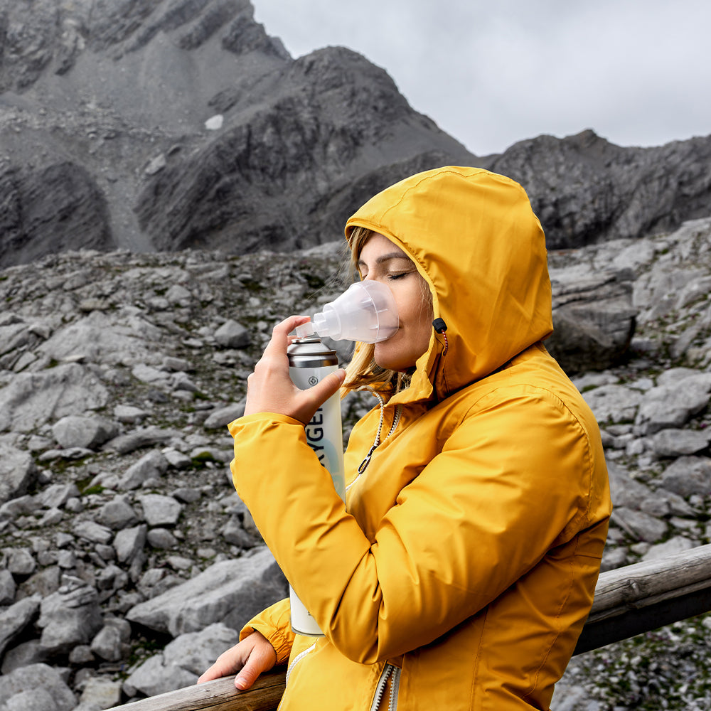 Sauerstoffmaske am Gesicht einer Person in gelber Outdoorjacke