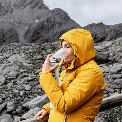 Sauerstoffmaske am Gesicht einer Person in gelber Outdoorjacke